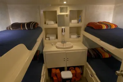 Quad cabin aboard Adventure with two sets of bunk berths and a washbasin between them
