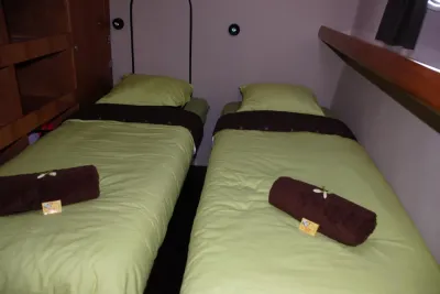 Twin cabin on Aqua Tiki II — two single beds along the hull sides