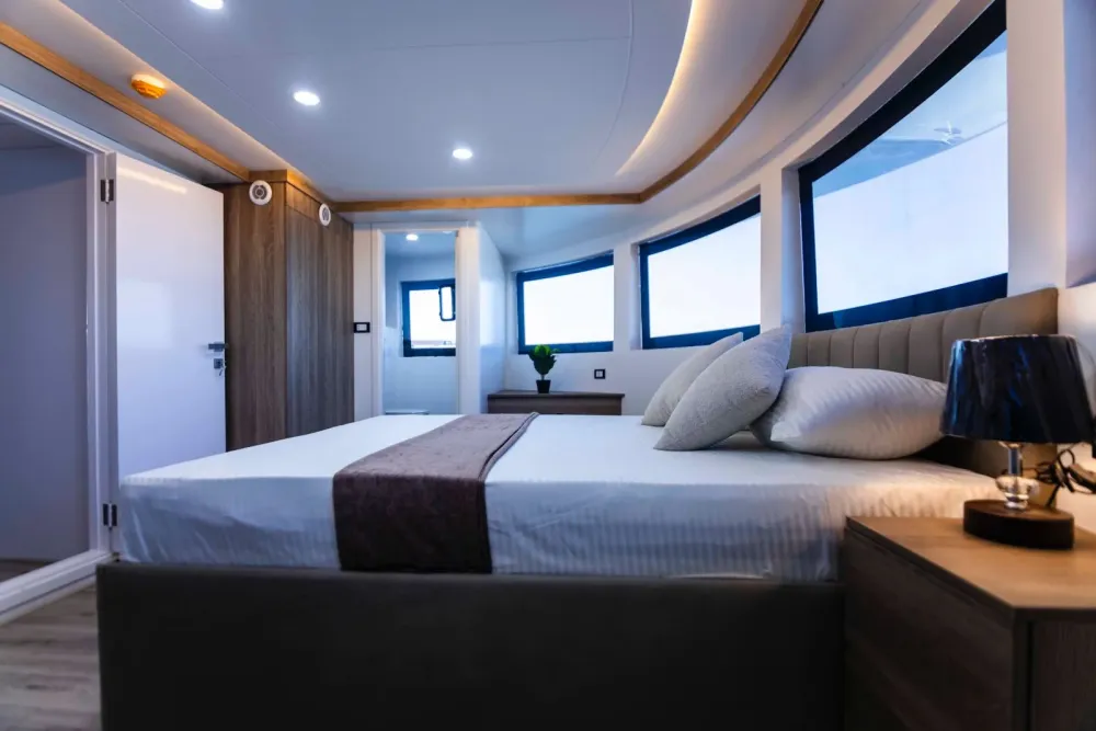 Master Suite Bismarck от входа — кровать, тумбы со светильниками и окна по всему носу