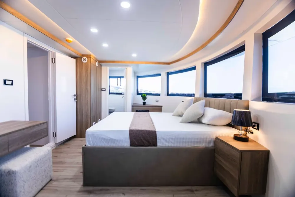 Интерьер Master Suite — светлое дерево, изголовье в рубчик и вид на марину из окон