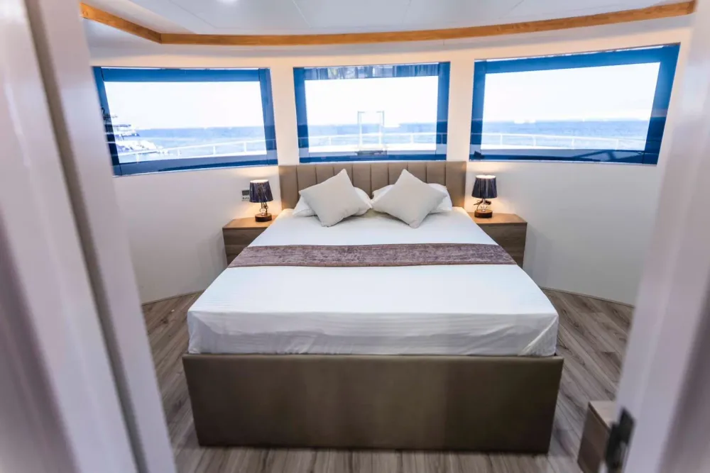Master Suite Bismarck — кровать по центру каюты и окна, выходящие на нос судна