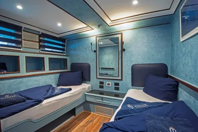 Каюта Classic Twin на нижней палубе Blue Melody — две односпальные кровати, зеркало и полки над изголовьями