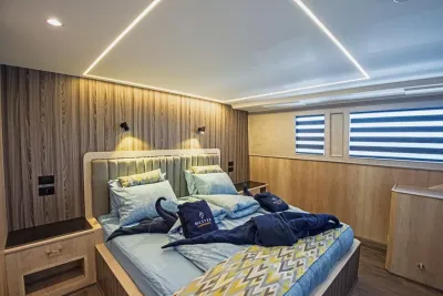 Каюта Premium Double на верхней палубе Blue Melody — двуспальная кровать у стены светлого дерева