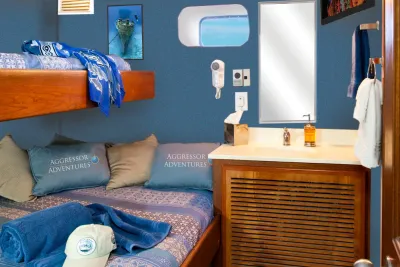Bunk-style stateroom on Cayman Aggressor IV with vanity and porthole