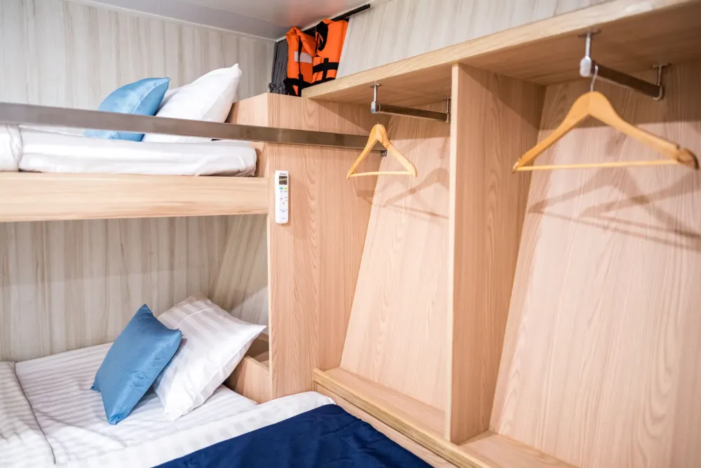 Open wardrobe and shelves in the Andaman Triple cabin