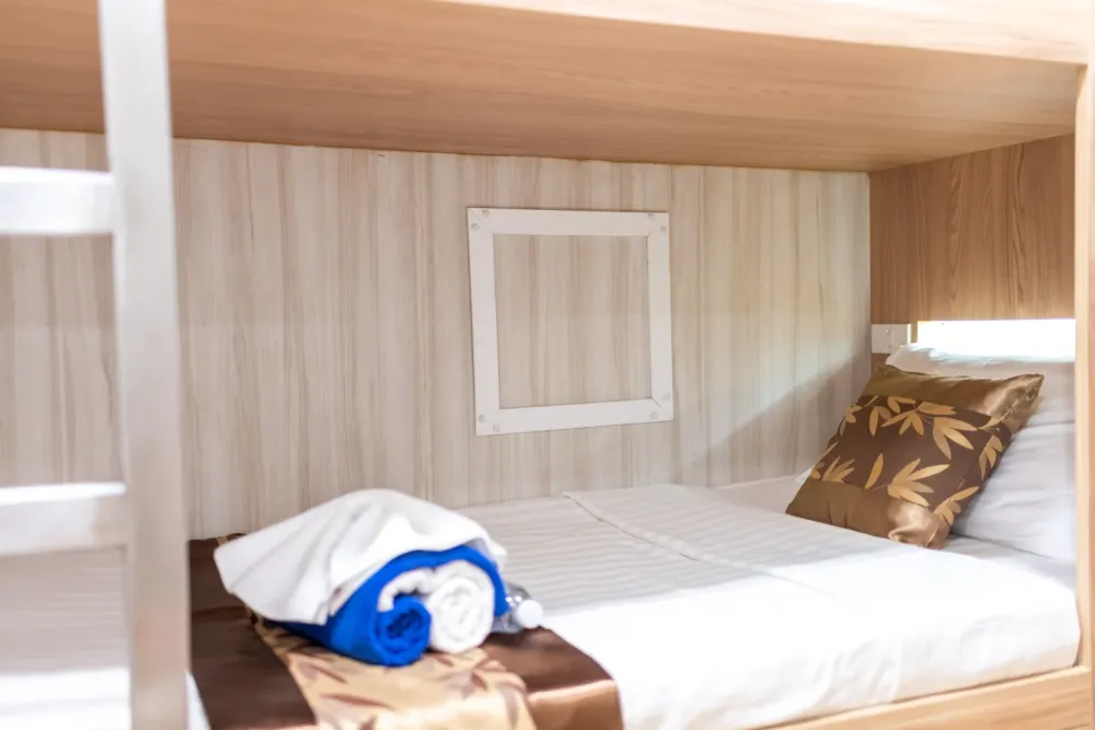 Lower berth of the Andaman Twin B cabin with a porthole