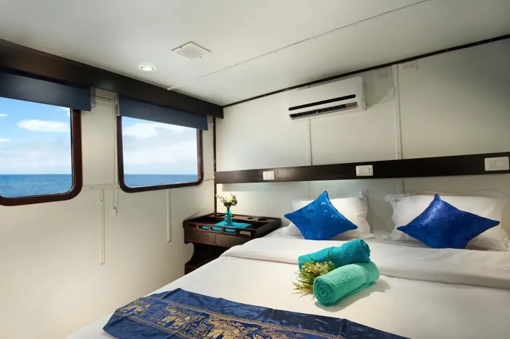 Upper deck cabin on Galapagos Master with a double bed and panoramic windows