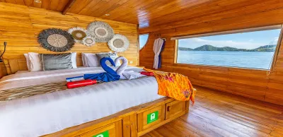 Balcony Suite on Komodo Aggressor — double bed beside a picture window looking out over the Komodo islands