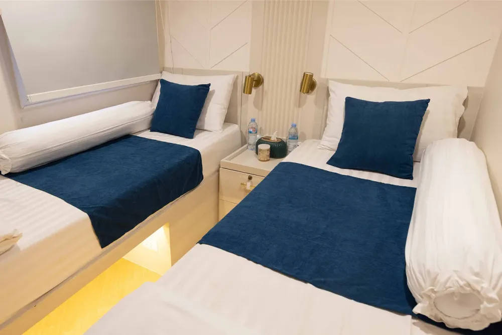 Cabin B5 on Krishna 3 — reading lights and water on the bedside table