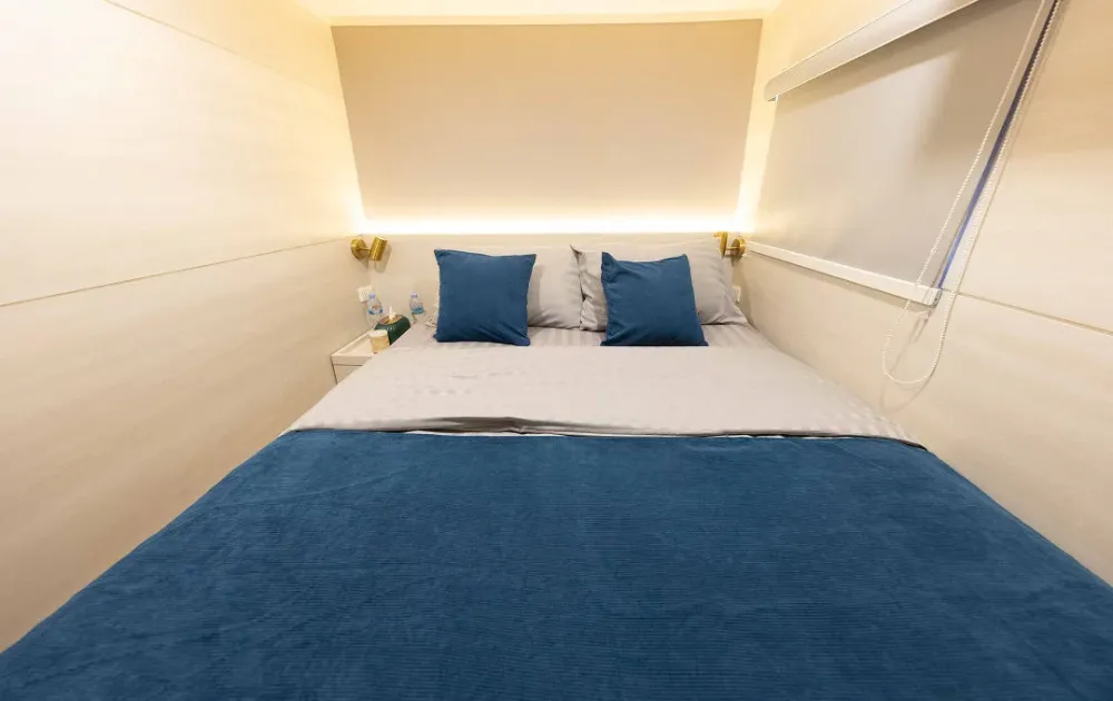 Double bed in a Krishna 3 deluxe cabin with a backlit headboard