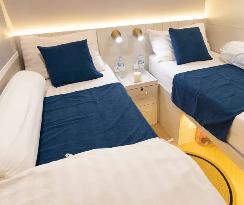 Twin beds in a Krishna 3 upper deck cabin with reading lights