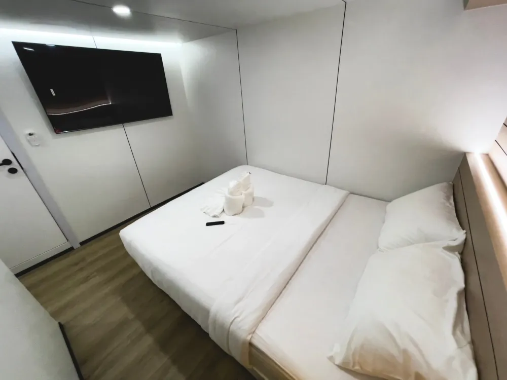 Lower deck master cabin on Mandarin Queen 9 — double bed and a TV