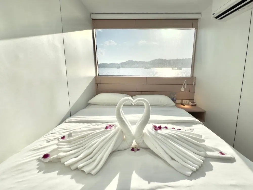 Double bed beside the window in a master cabin on Mandarin Queen 9
