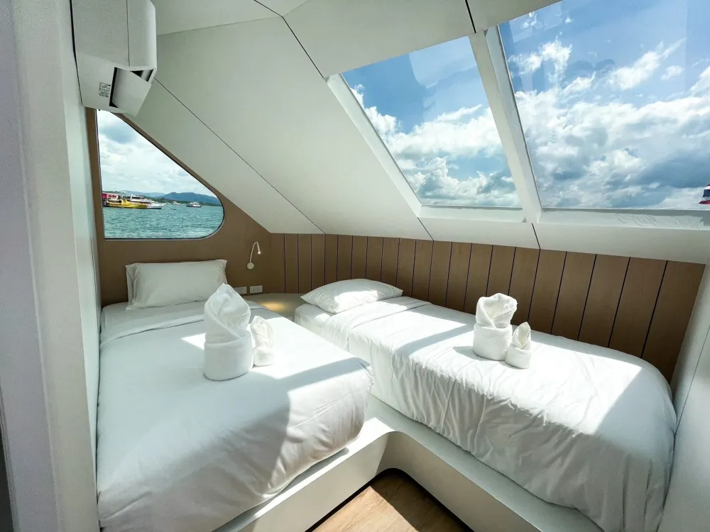 Forward twin cabin on Mandarin Queen 9 — beds beneath slanted windows