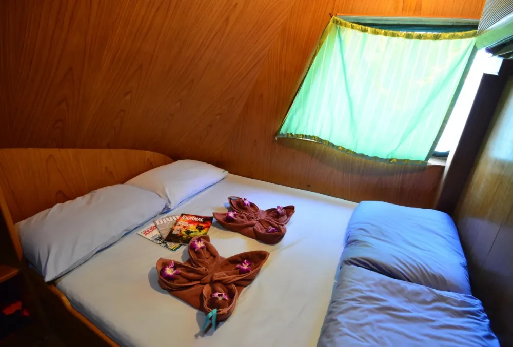 Double cabin on Manta Queen 2 with a window and wooden panels