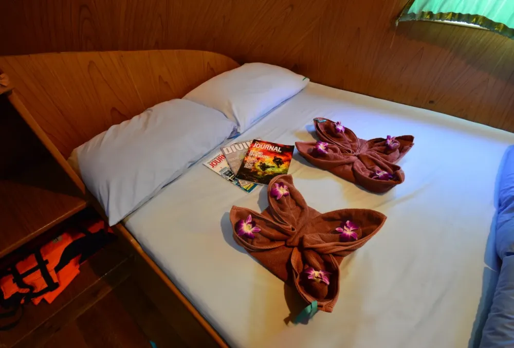 Double bed on Manta Queen 2 with towels folded into flowers