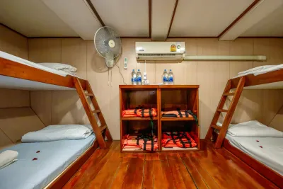 Four-berth cabin on Manta Queen 2 — two sets of bunks with shelving between them