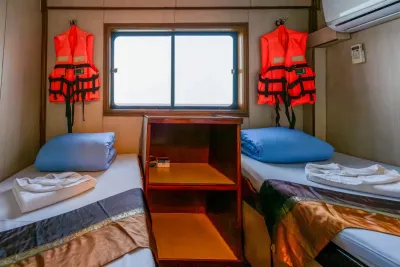 Twin cabin on Manta Queen 2 — two single beds either side of a window