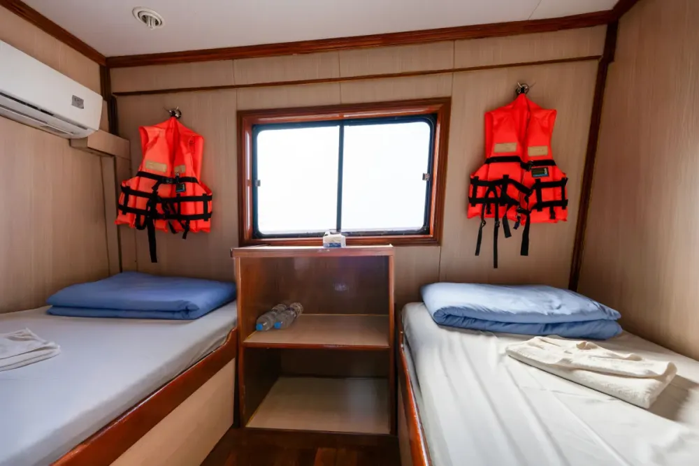 Air-conditioned twin cabin with a window on the main deck of Manta Queen 2