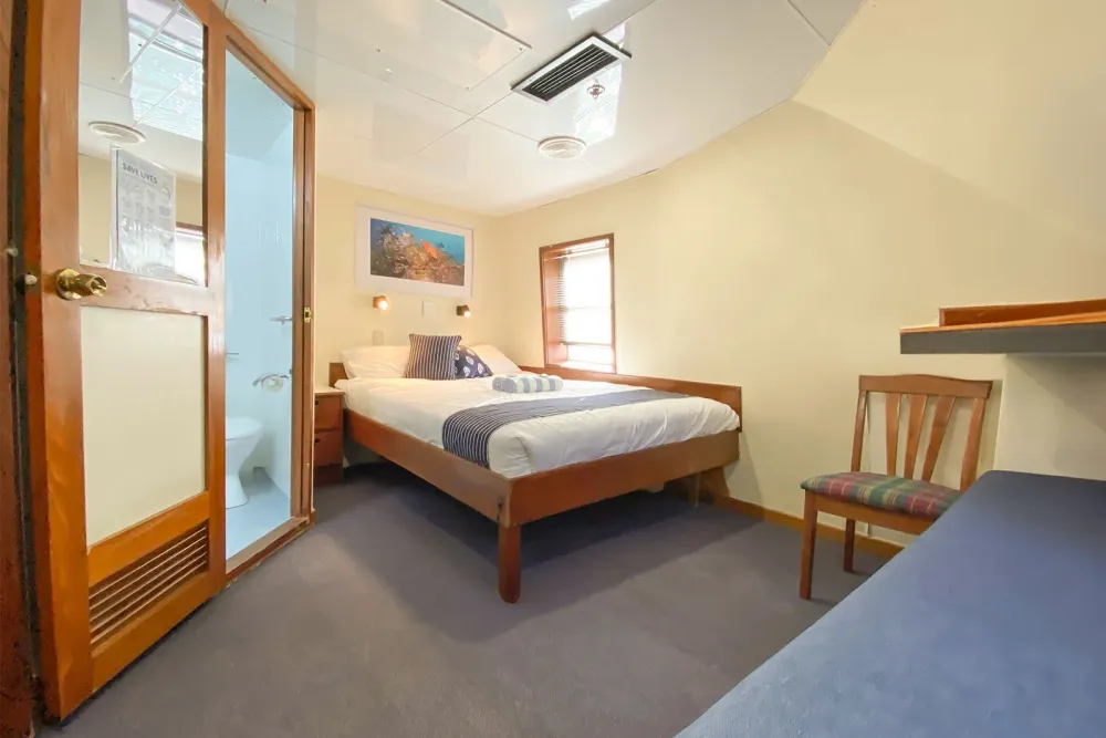 Double cabin on Ocean Quest — double bed and a shower behind a glass door