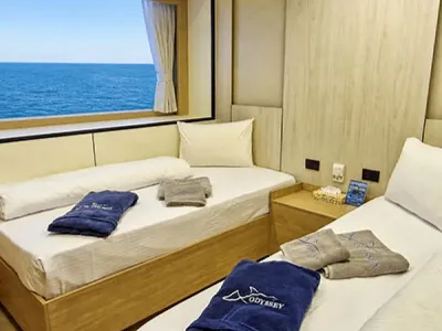 Twin cabin on Odyssey — two single beds and towels embroidered ODYSSEY
