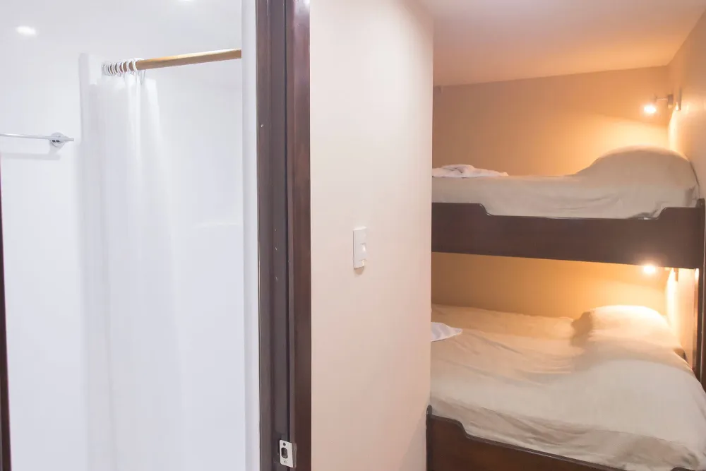 Deluxe stateroom on Okeanos Aggressor II — bunk beds and the shower entrance