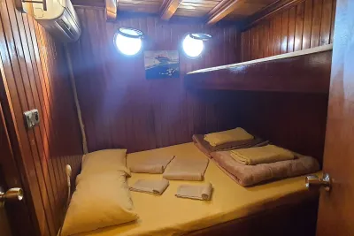 Wooden Okyanus JD cabin with a double bed, shelf and air conditioning unit