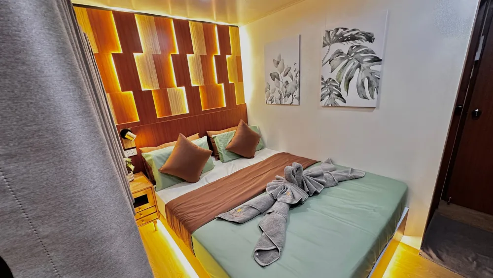 Raga standard cabin with a double bed and a backlit headboard