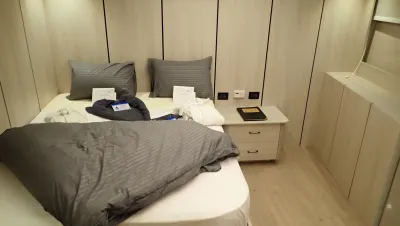 Каюта Master на Red Sea Aggressor V — двуспальная кровать у светлой переборки и тумба с ящиками