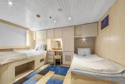Twin Suite on the main deck of Royal Evolution with two beds and a sea-view window