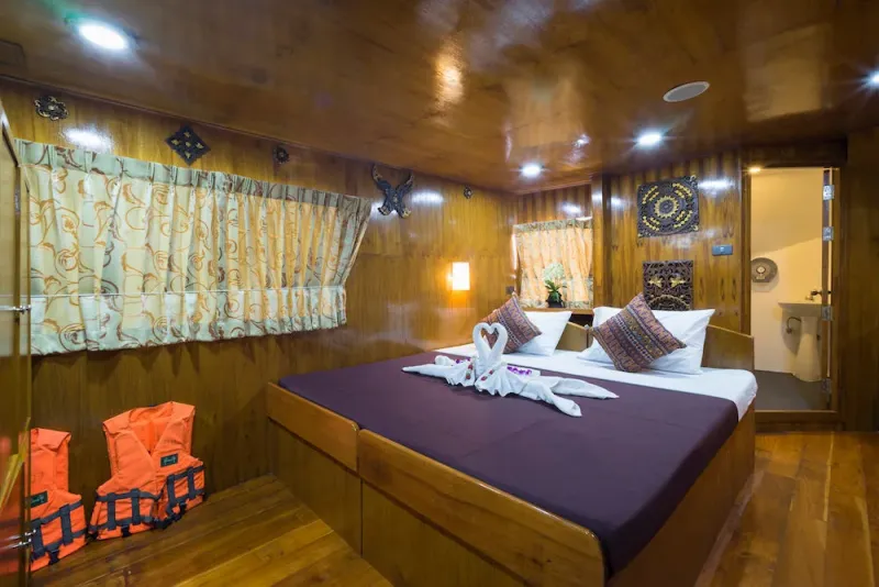 Master cabin on Sawasdee Fasai — queen-size bed in wood-panelled interior