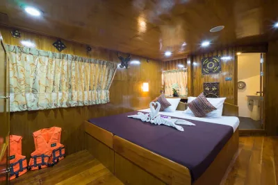 Master cabin on Sawasdee Fasai — queen-size bed in wood-panelled interior