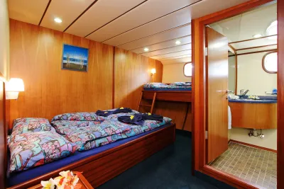 Sea Bird triple cabin — double bed, upper bunk and the door to the bathroom