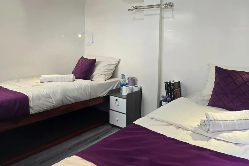 Upper deck cabin with a cabinet between the beds