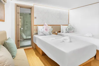 Cabin 101 on the lower deck of Solitude Gaia — beds pushed together and the bathroom door