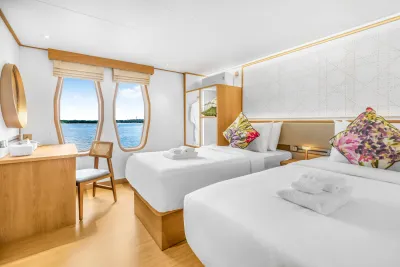 Cabin 203 on the main deck of Solitude Gaia — two single beds by the portholes