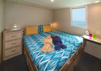 VIP stateroom on Turks & Caicos Explorer II — queen bed and ocean-view window