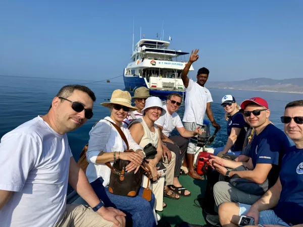 Group on the tender — yacht Oman Explorer behind