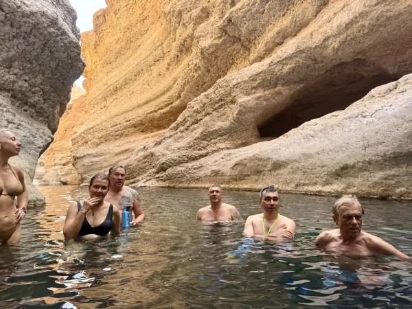 Group swimming in the canyon — golden cliffs around