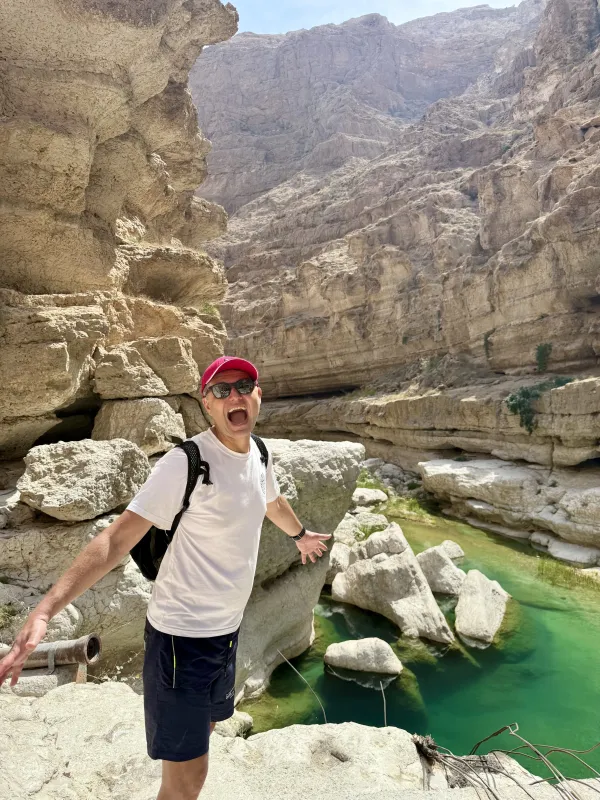Turquoise canyon water — arms raised in delight
