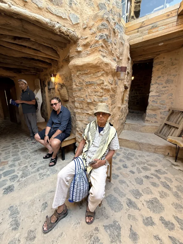 Stone village — a local in a keffiyeh and a traveller on a stone bench