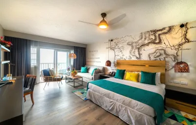 Deluxe Oceanfront Room — кровать, зона отдыха и балкон