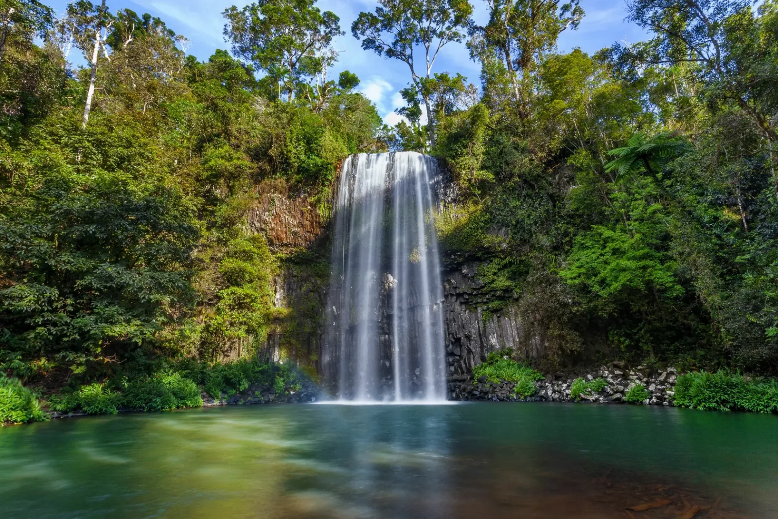 Водопад в тропическом лесу с изумрудным озером