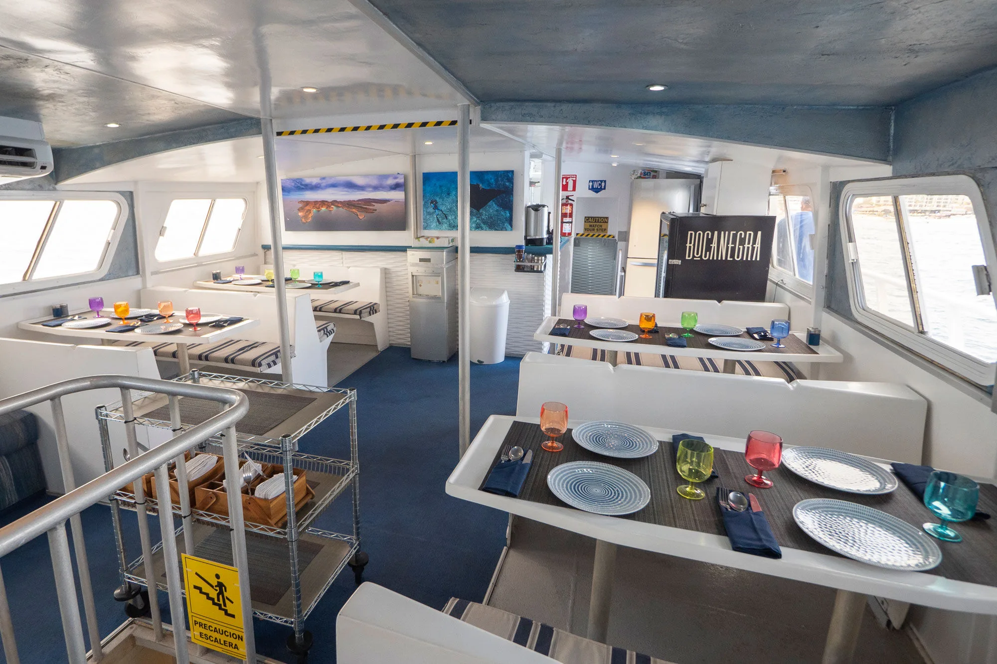 Dining salon aboard Adventure with tables laid for a meal