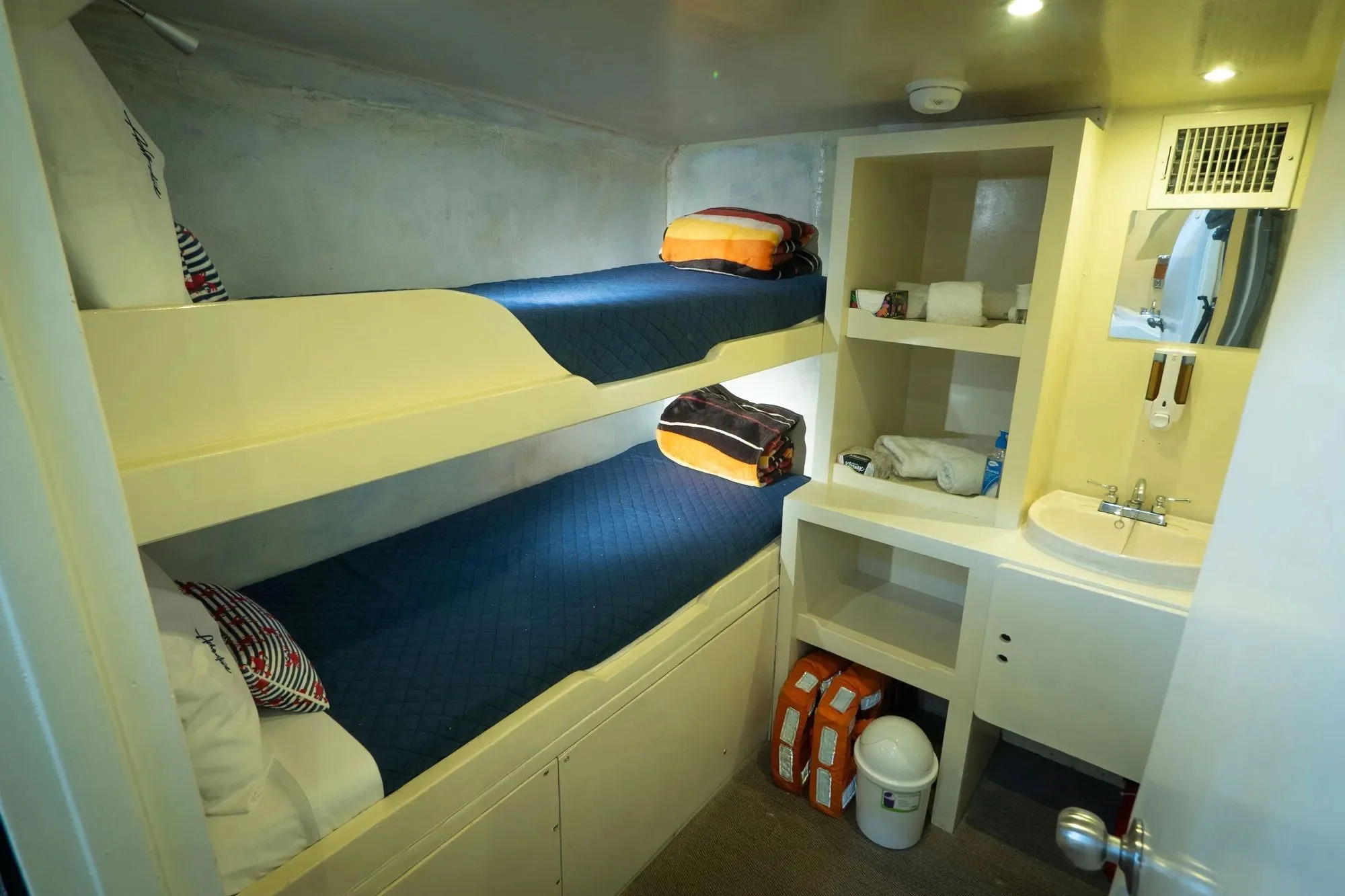 Inner deck double cabin aboard Adventure with bunk berths, shelving and a washbasin