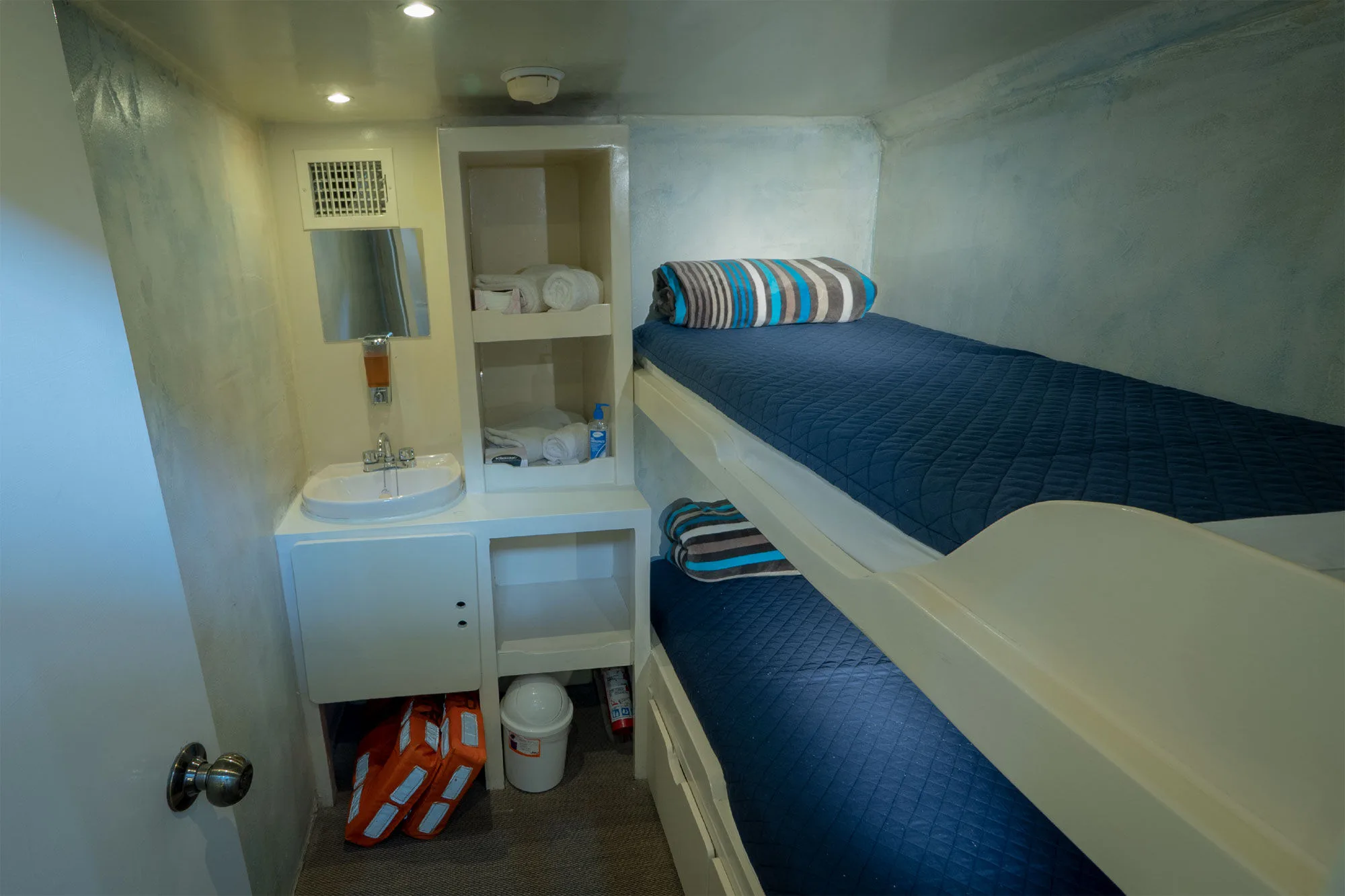 Upper deck double cabin aboard Adventure with bunk berths and a vanity mirror