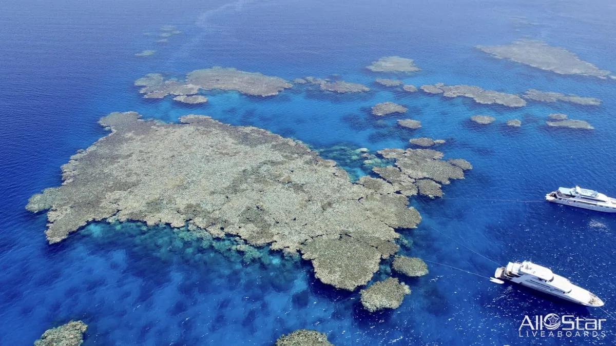 Судно у кораллового рифа в бирюзовой воде Красного моря
