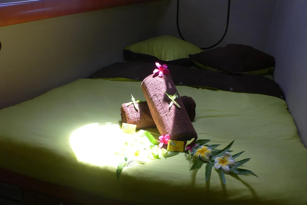 Double cabin on Aqua Tiki II — double bed with flowers laid on the cover