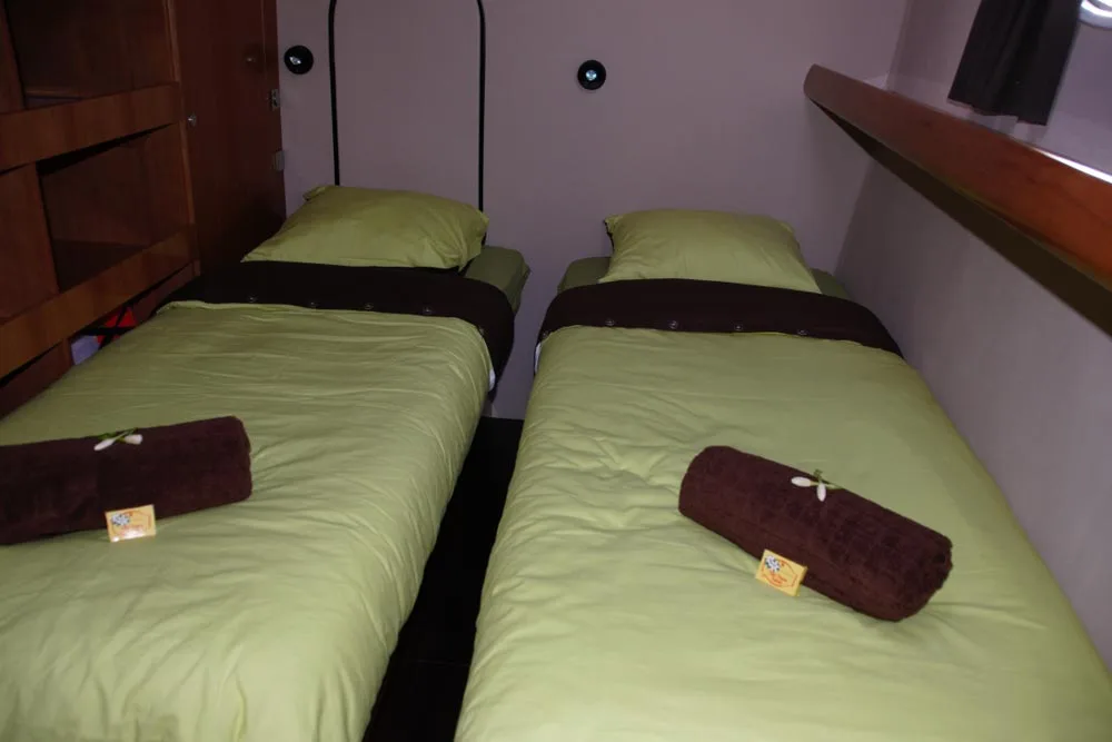 Twin cabin on Aqua Tiki II — two single beds along the hull sides