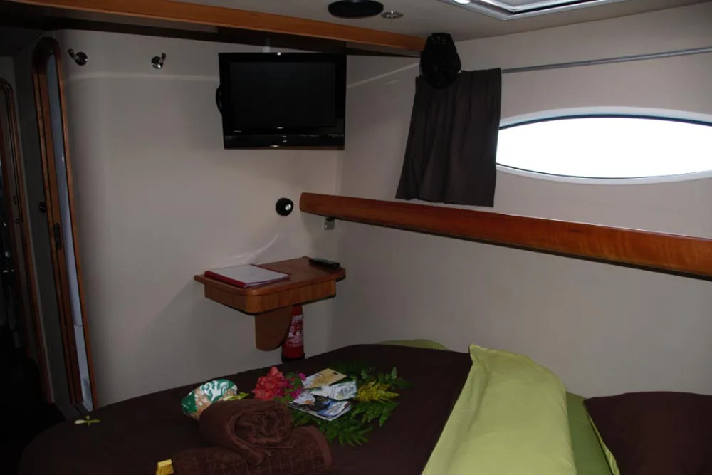 VIP cabin on Aqua Tiki II — television above the bed and a porthole